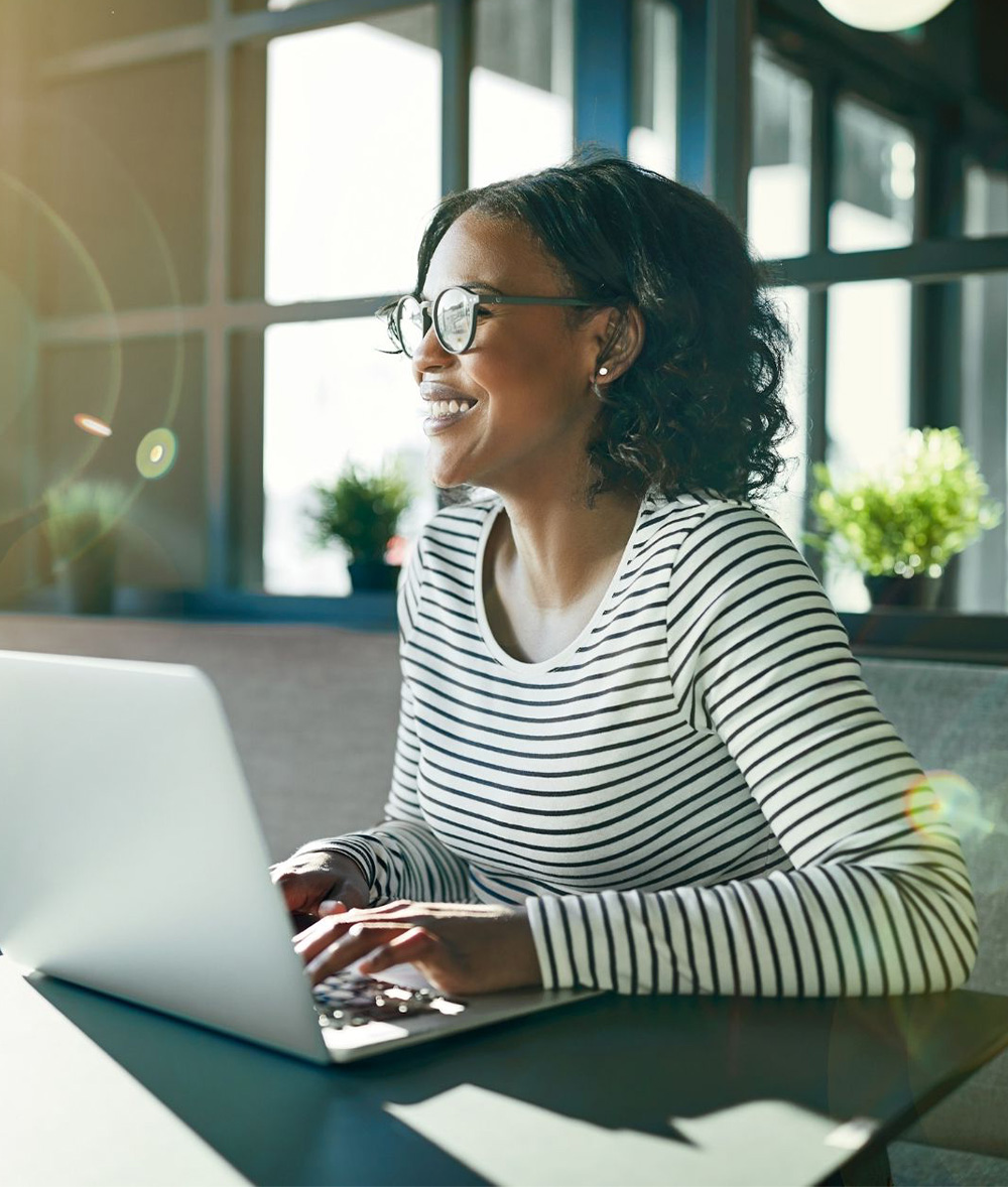 Woman smiling while using a laptop